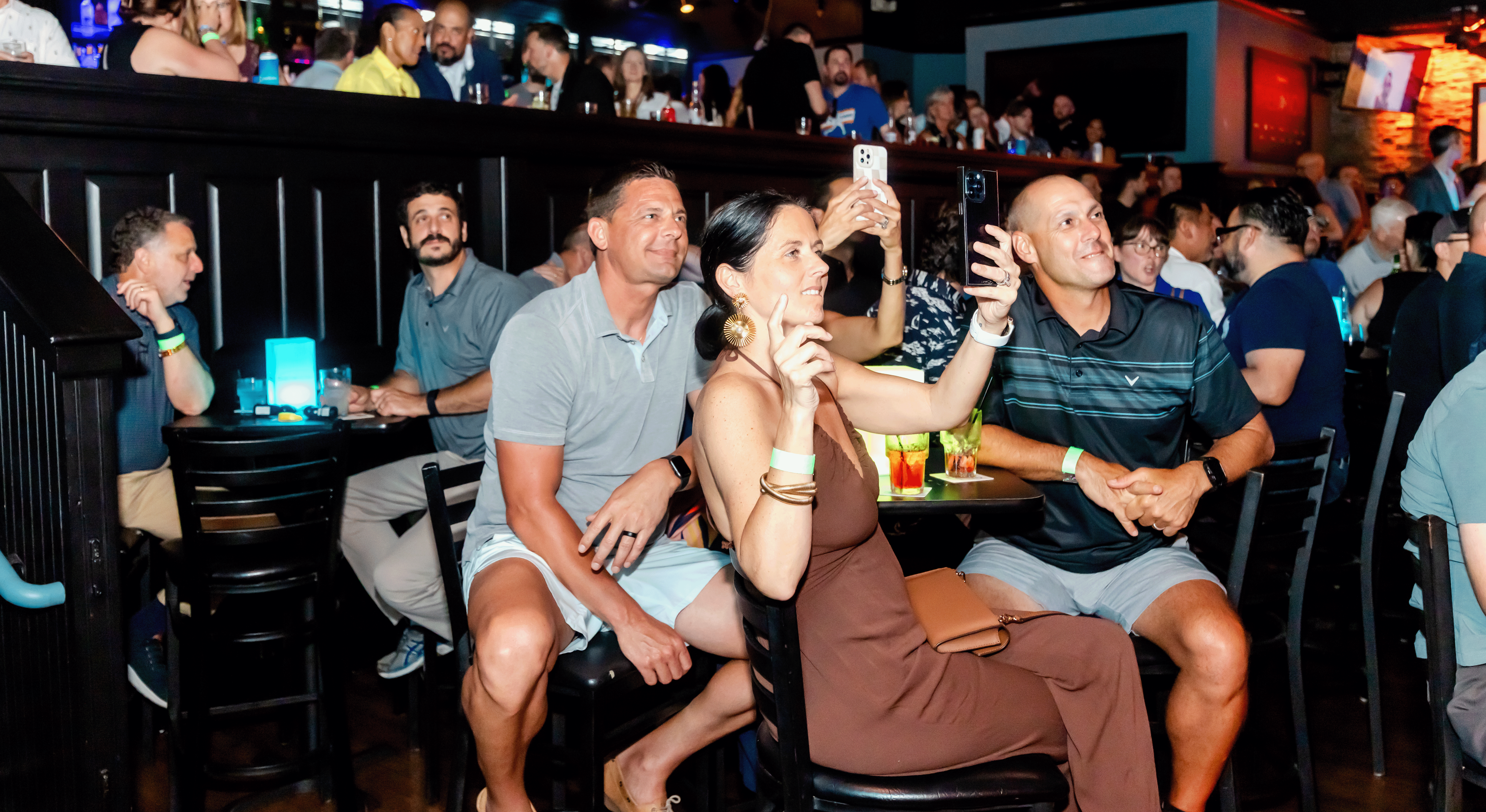A group of people enjoying a performance while sitting at a reserved table