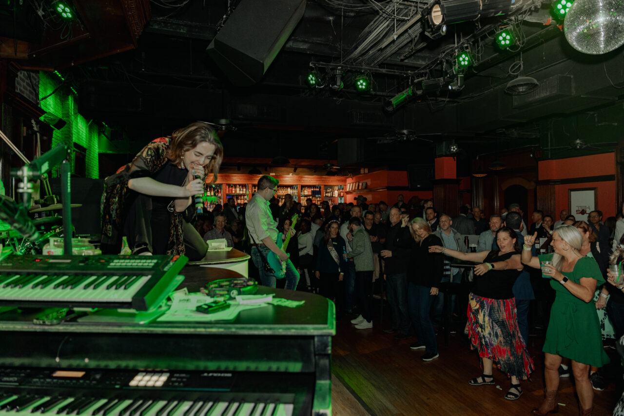 Performer on stage playing music and singing to a crowd