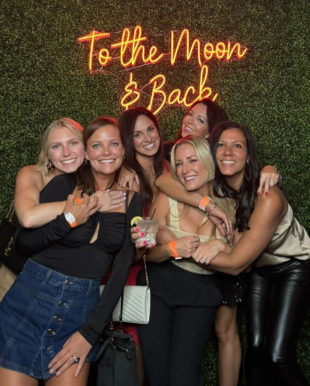 Group of women in front of neon sign