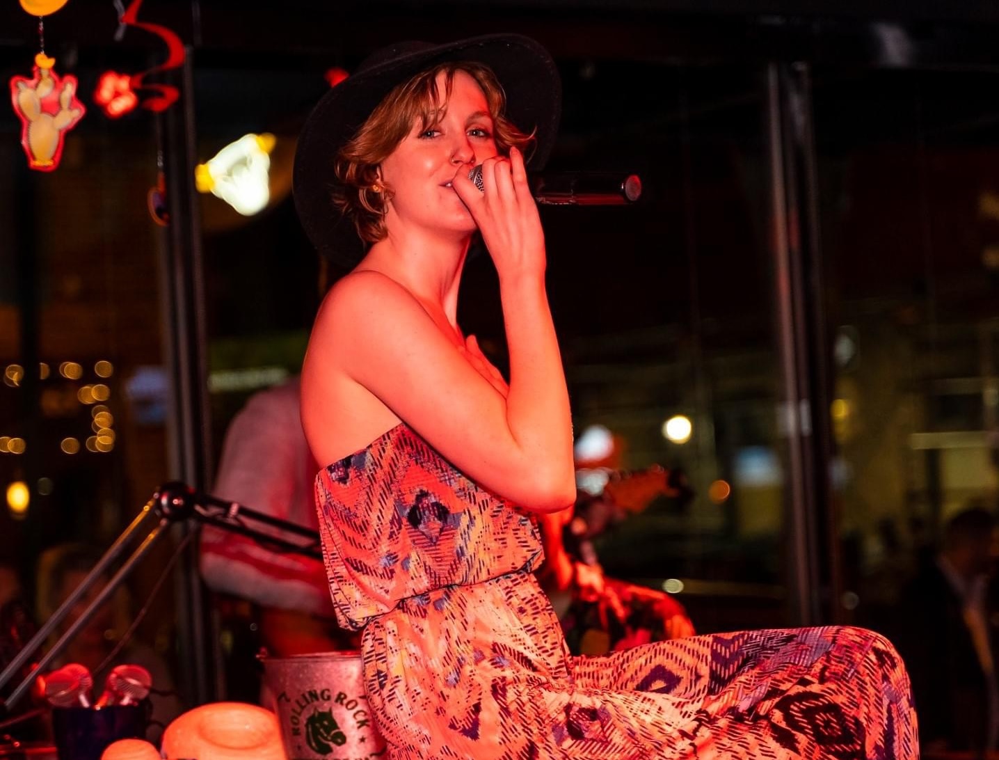 Live singer performing on stage at Howl at the Moon with microphone during a Cinco de Mayo nightlife event. Cinco de Mayo Specials.