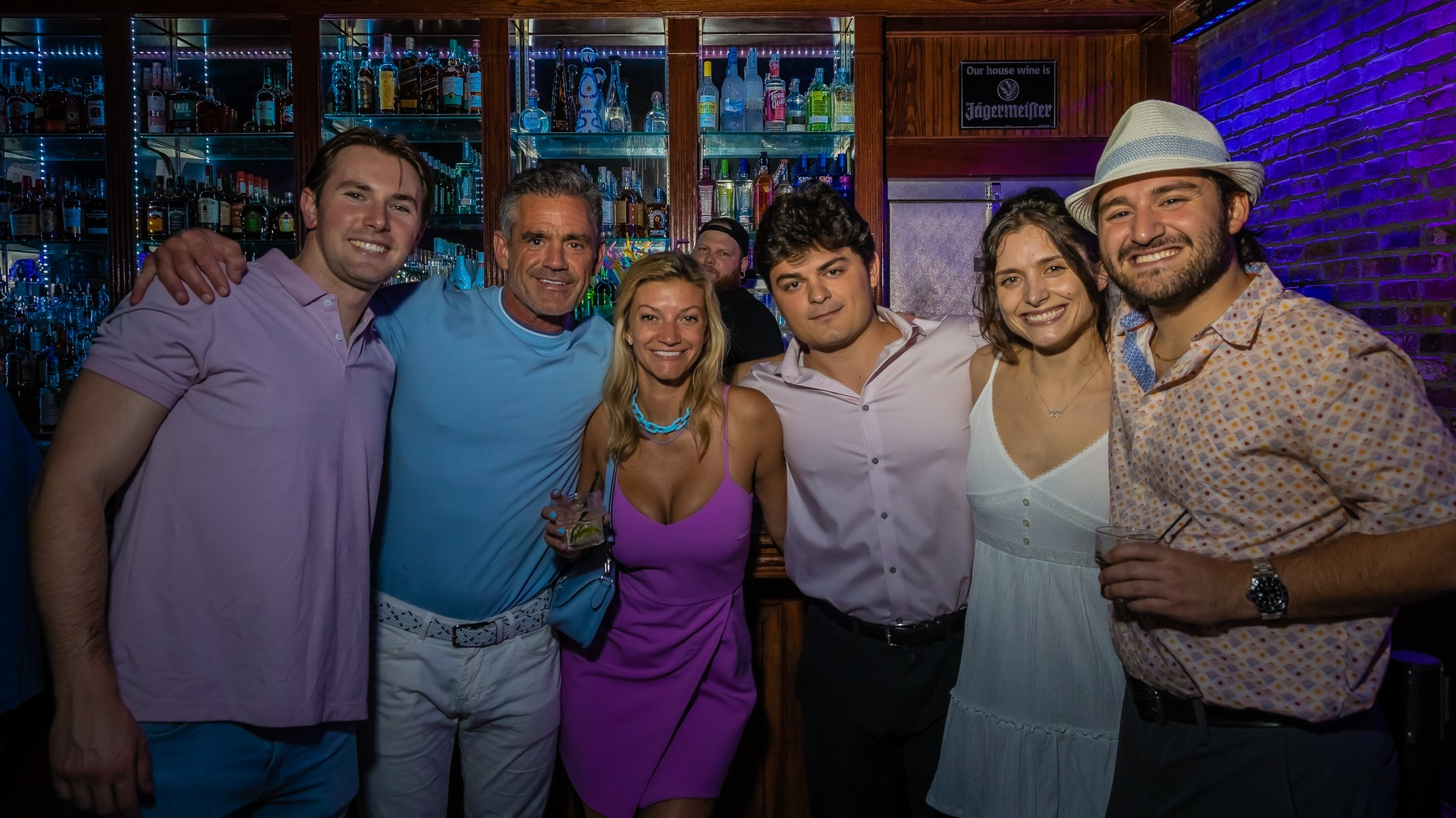 Friends posing at the bar during the Louisville Kentucky Derby party at Howl at the Moon with cocktails and Derby weekend nightlife in Louisville.