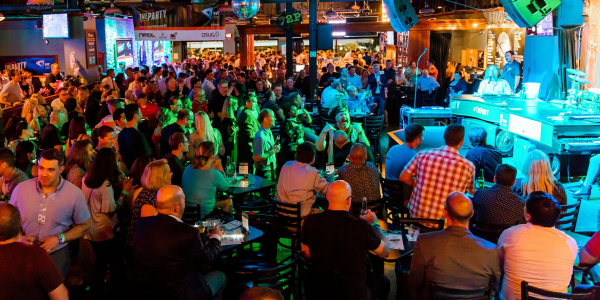 Large crowd enjoying a private event buyout at Howl at the Moon with live music, full venue crowd, and guests seated and standing around the stage