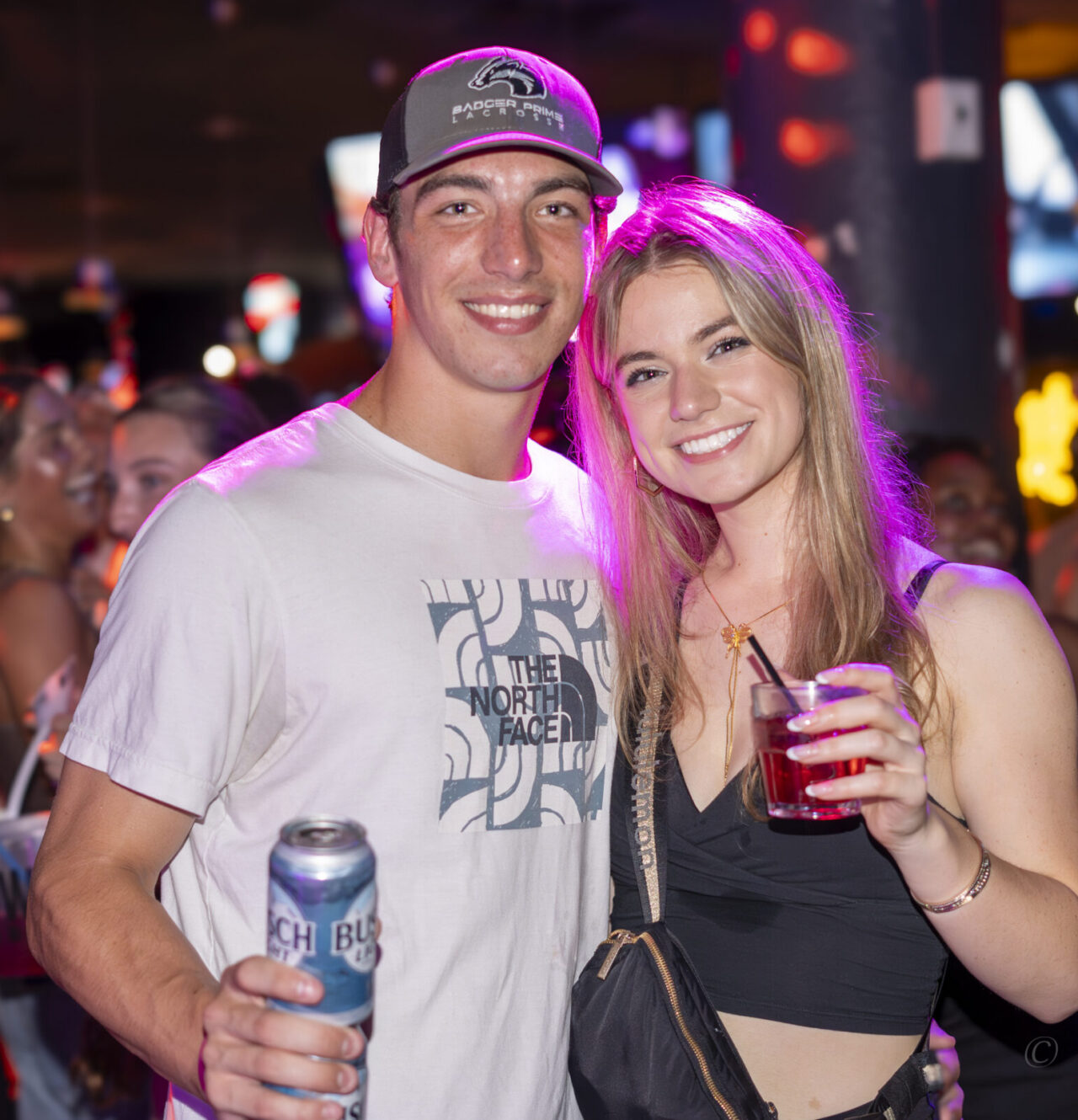 Couple smiling with drinks during Happy Hour at Howl at the Moon.