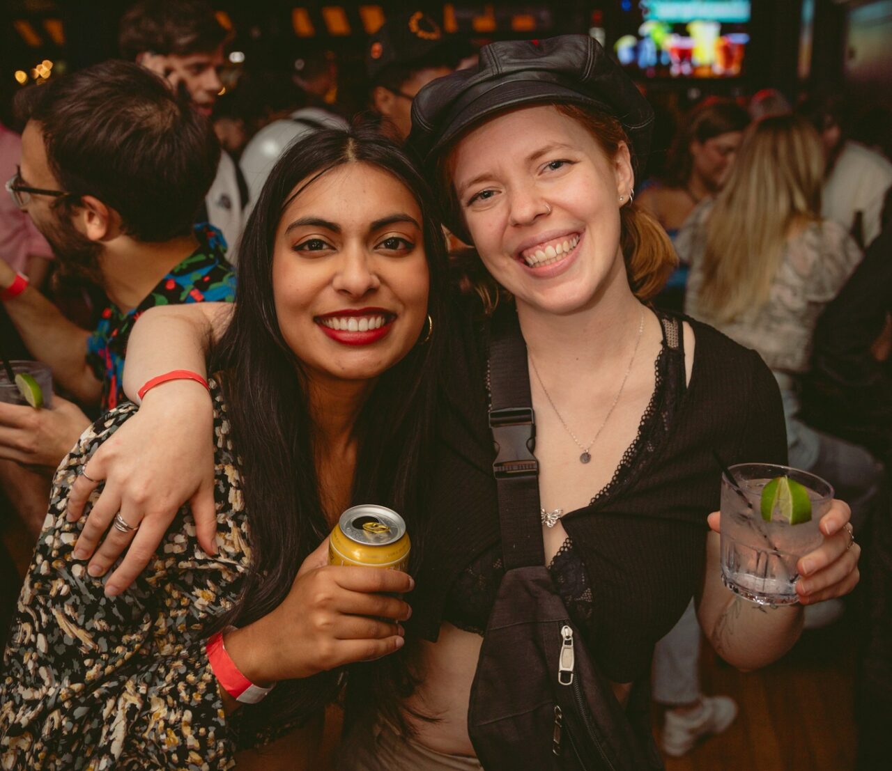 Friends smiling with drinks during Chicago Happy Hour at Howl at the Moon.