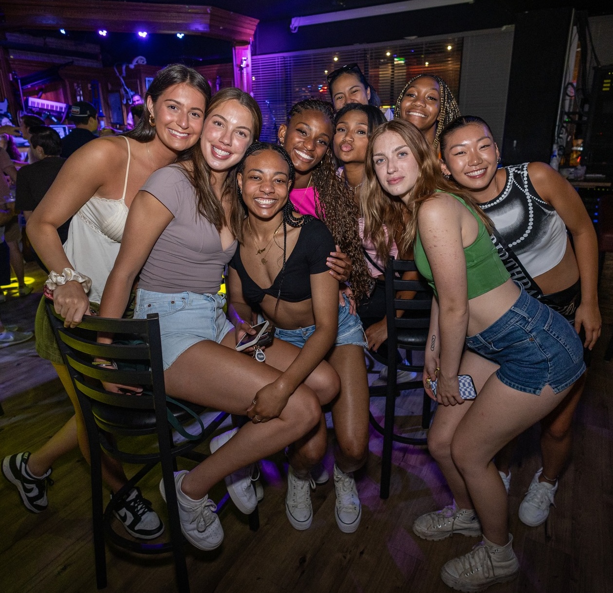 Friends posing together during the Boston Win a Party celebration at Howl at the Moon.