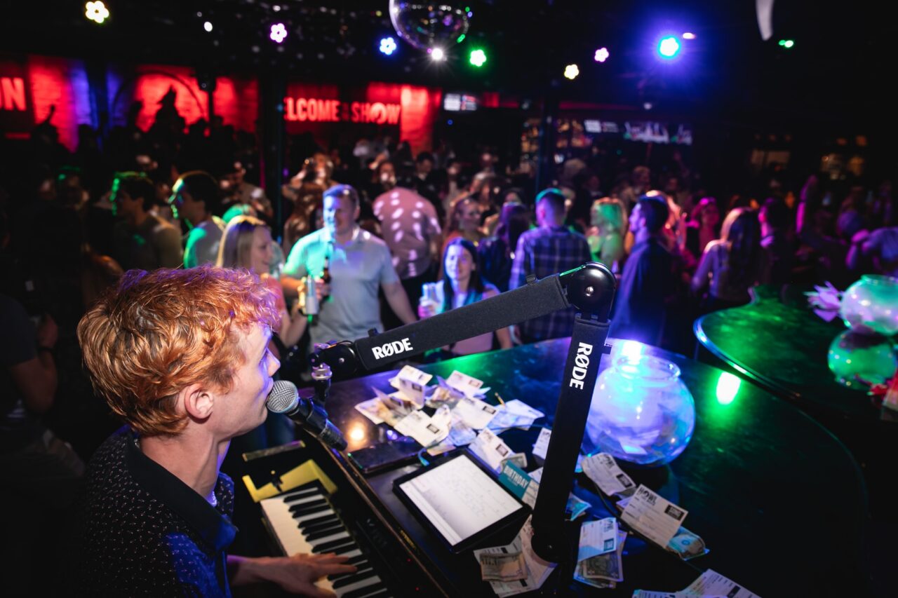 Piano entertainer performing live in front of a crowd during Chicago Happy Hour at Howl at the Moon.