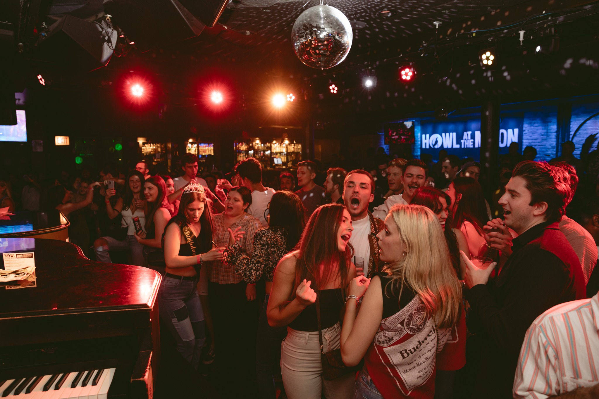 Crowd gathered around the piano singing and celebrating during Chicago Happy Hour at Howl at the Moon.