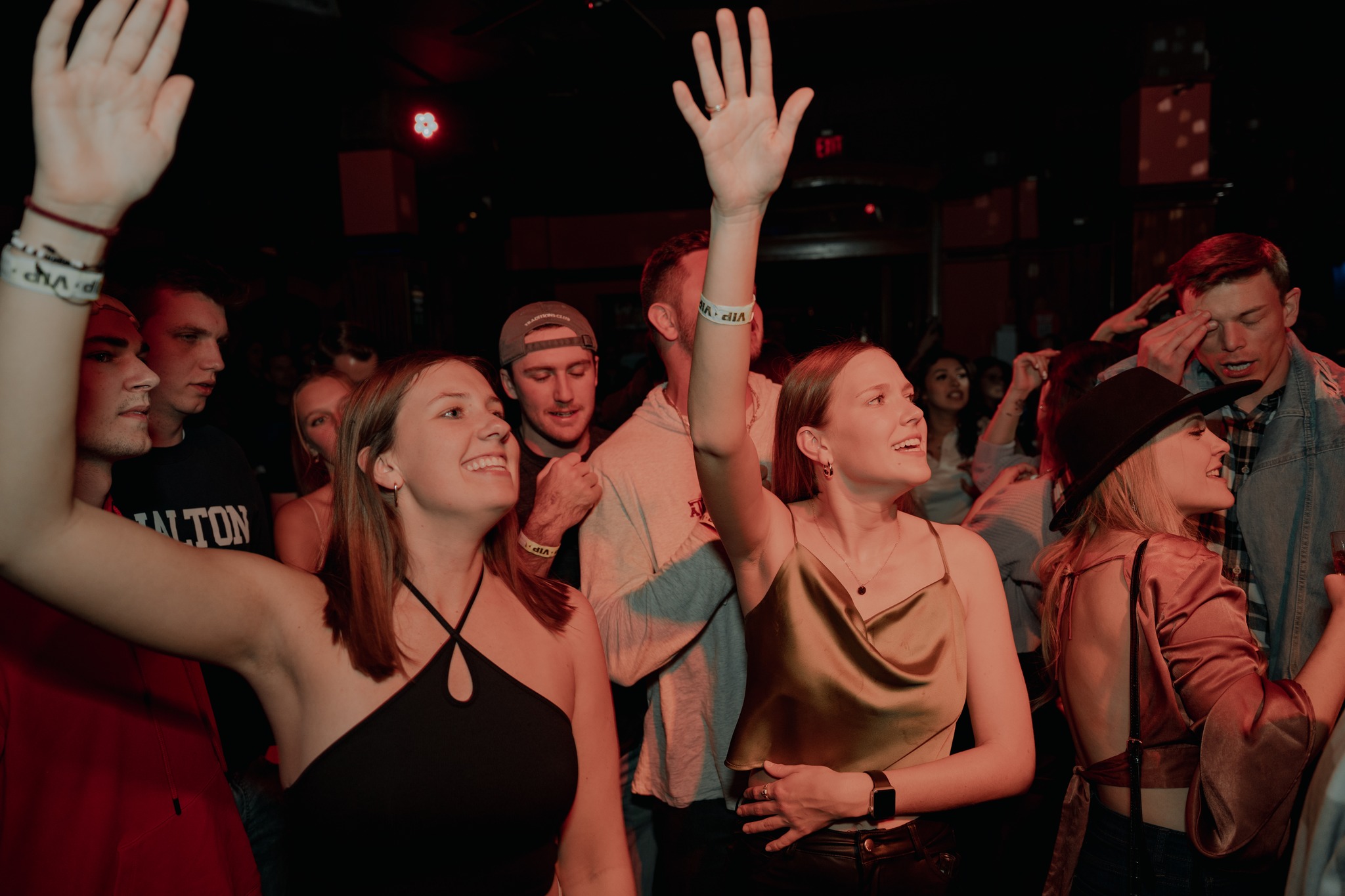 Guests raising their hands and enjoying live music during San Antonio Happy Hour.