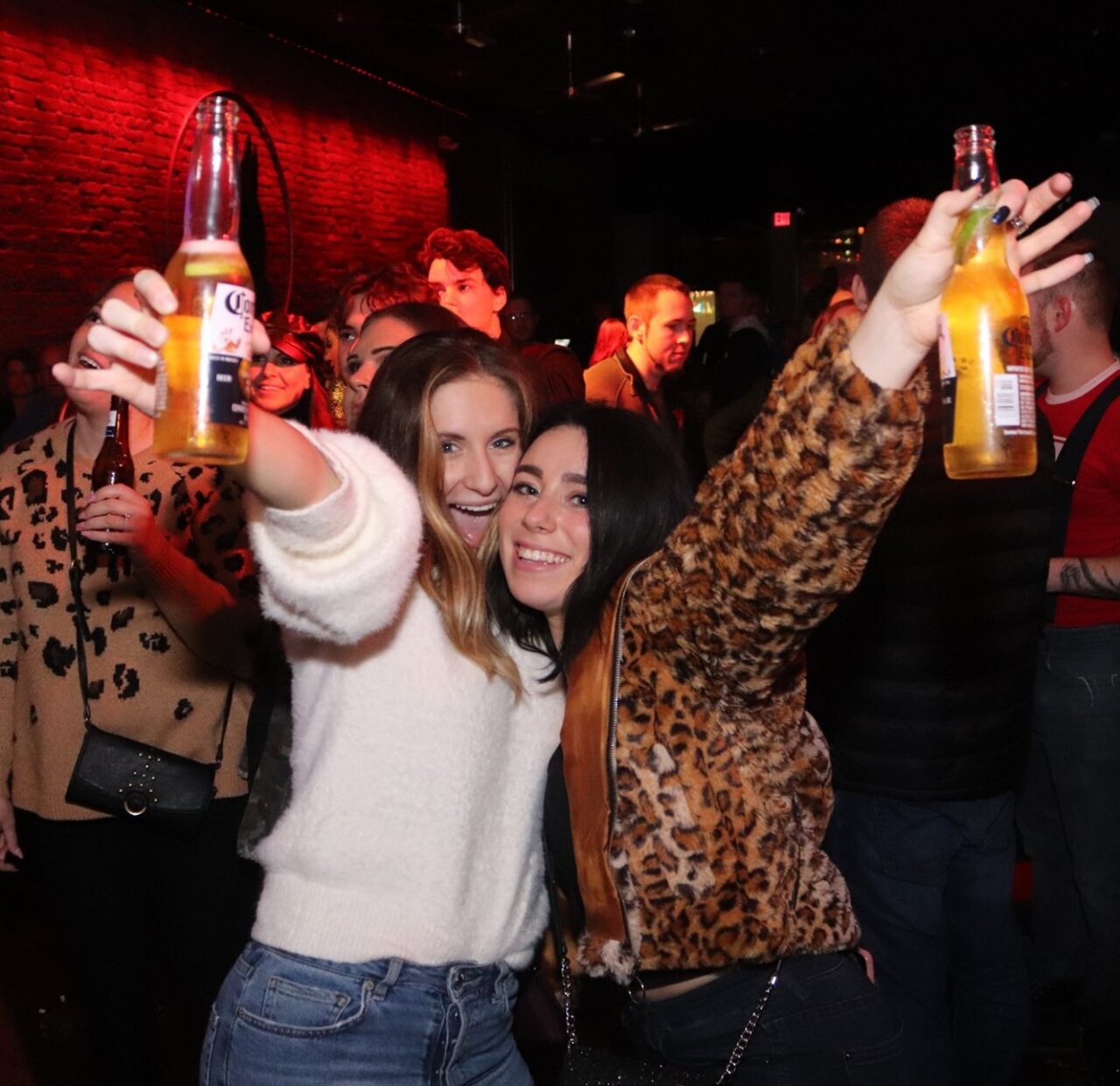 Friends raising beers and celebrating during Pittsburgh Happy Hour at Howl at the Moon.