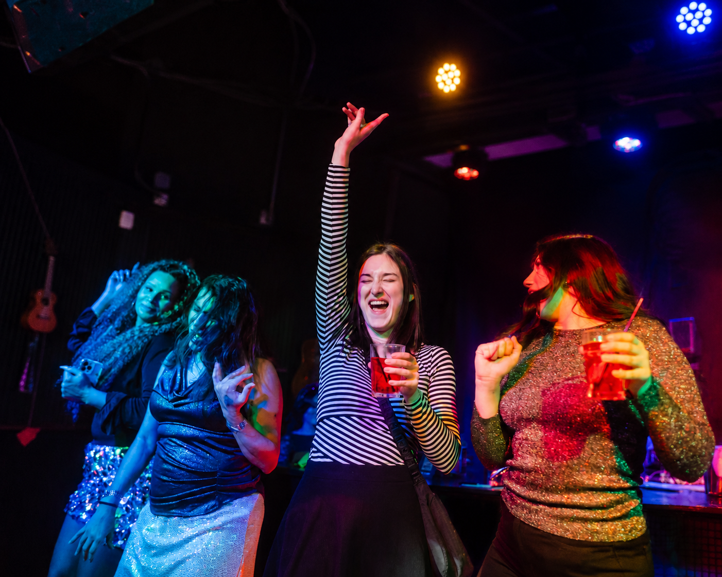 Friends dancing and celebrating during Indianapolis Happy Hour at Howl at the Moon.